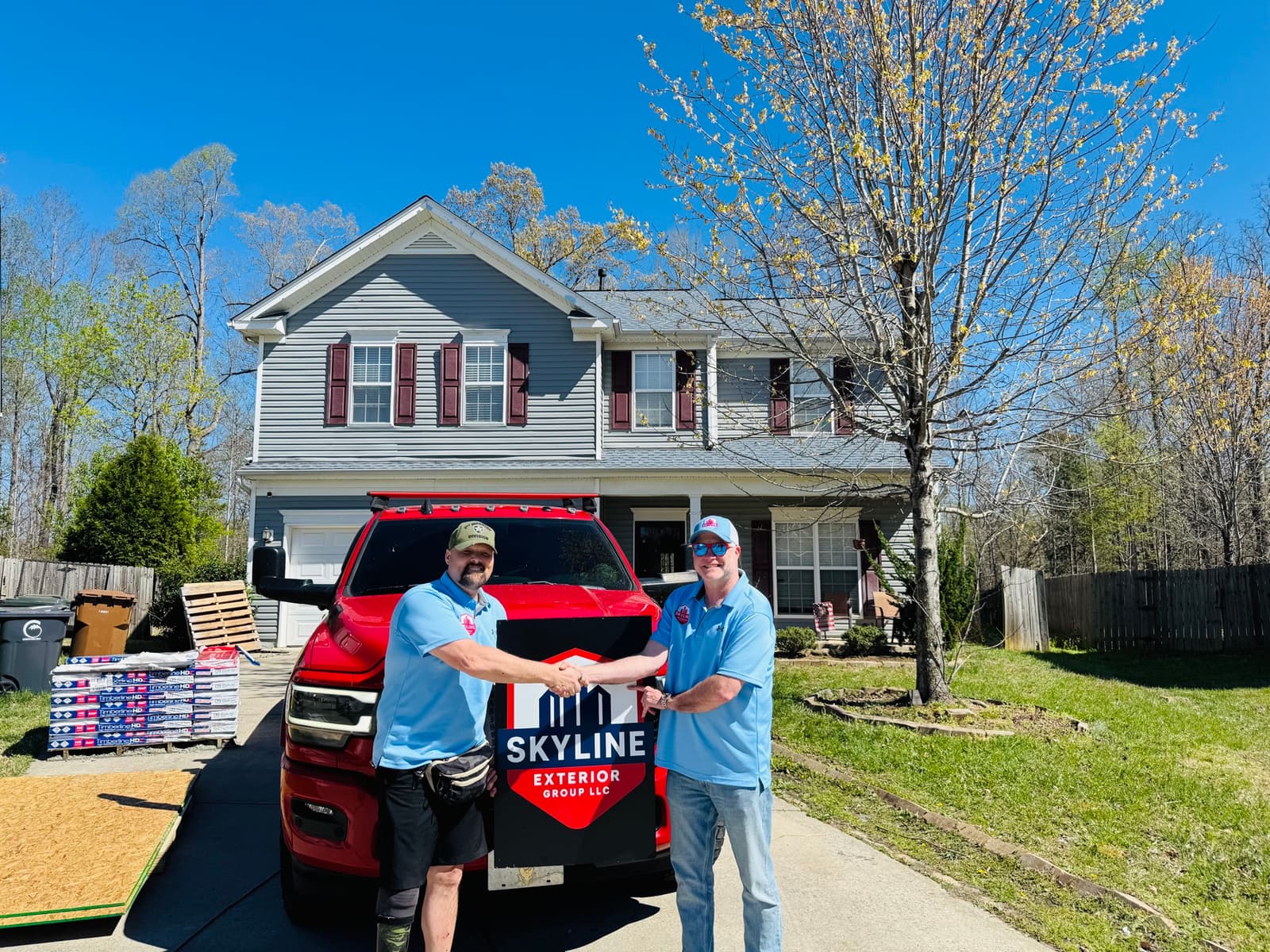 U.S. Army veteran Grady Bendel, left, shaking hands with Skyline Exterior Group founder Brian Rice outside Bendel's Greensboro home after the first 100 Roof Promise roof replacement, March 28, 2026