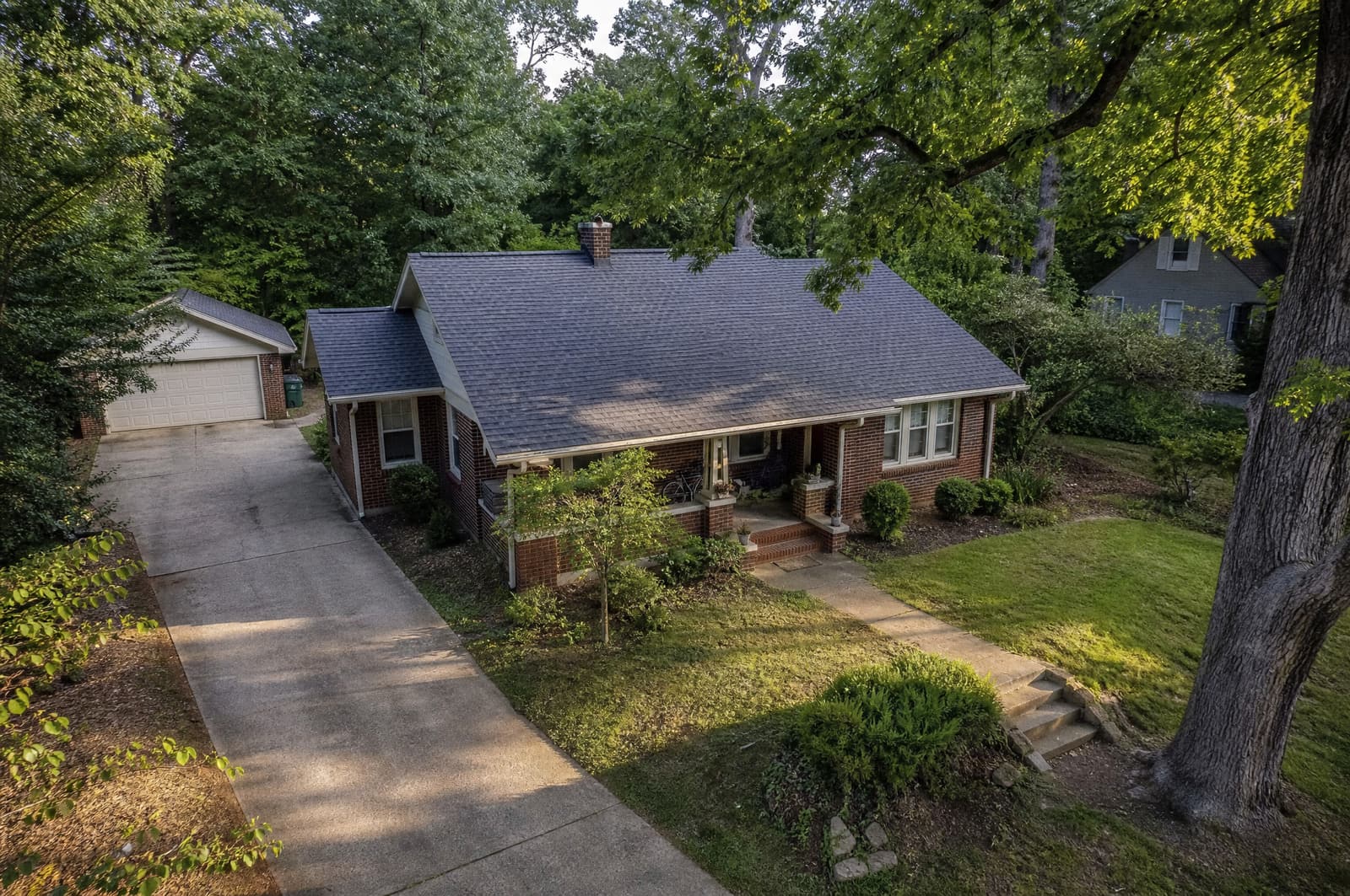 Bungalow on a tree-lined street in Carrboro, NC with a new slate gray shingle roof, aerial view