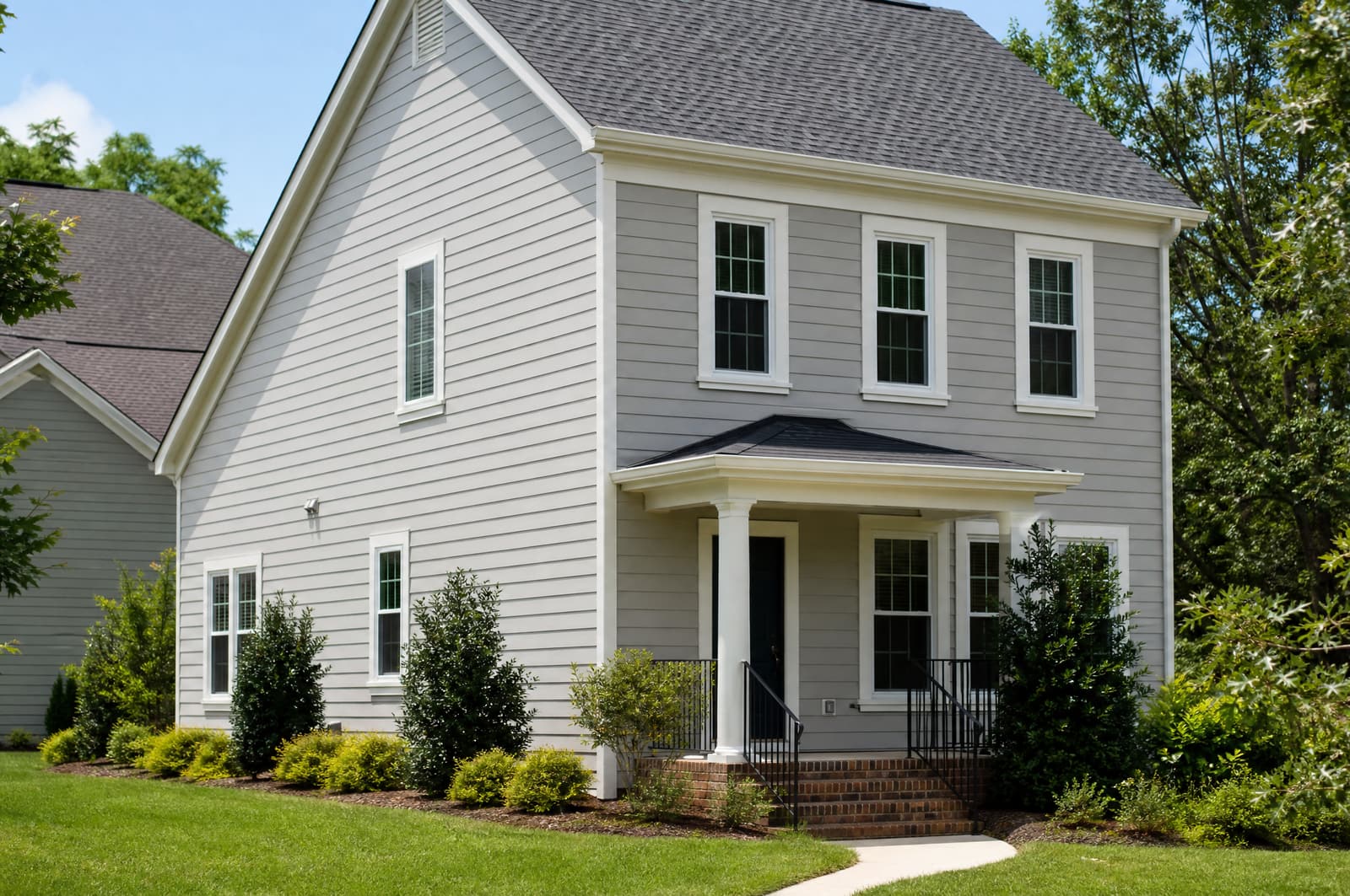 Home with new light gray fiber cement lap siding and white window trim