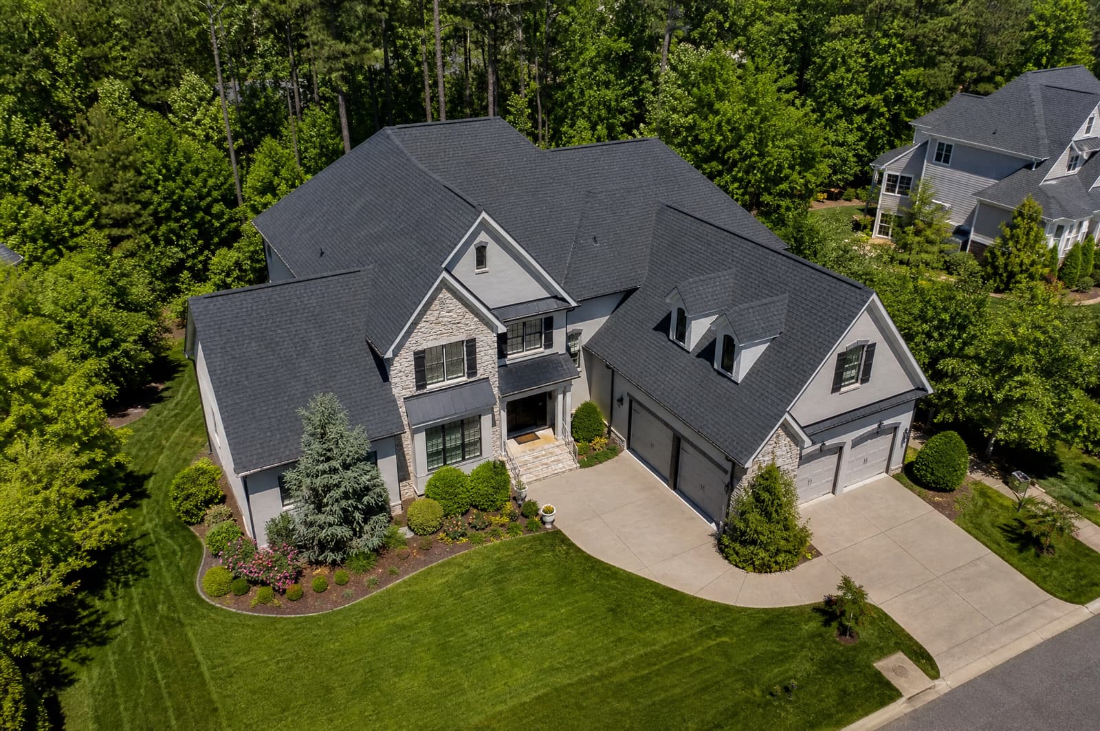 Large home in Cary, NC with a new charcoal shingle roof over multiple gables and dormers, aerial view