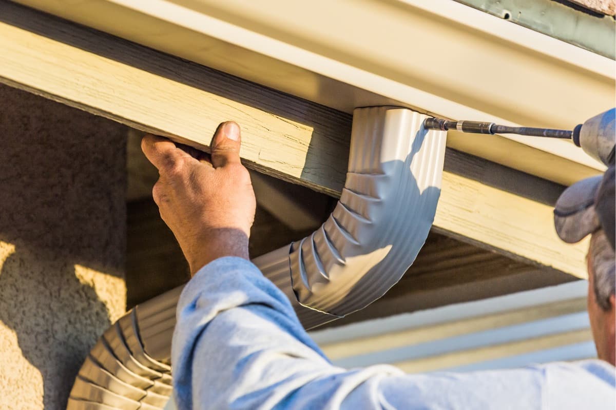 Skyline crew installing a new downspout during a seamless gutter installation in North Carolina